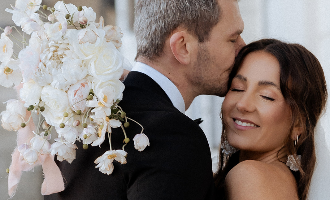 Portrait vom wunderschönen Brautpaar. Mann küsst Braut